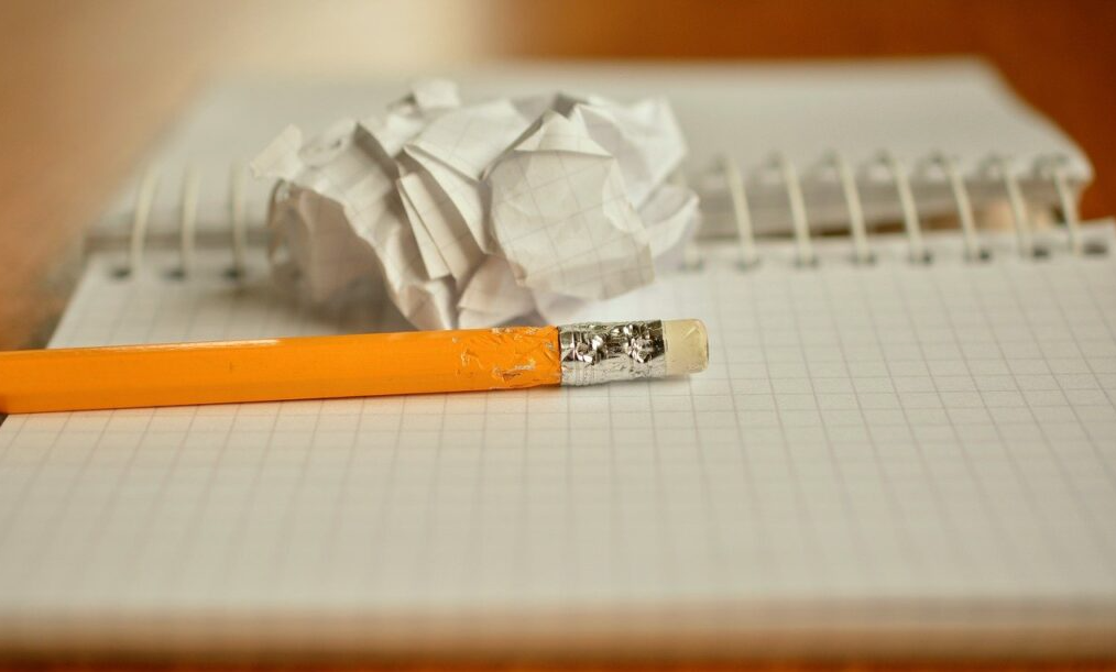 Cuaderno, lápiz y una hoja de papel arrugada